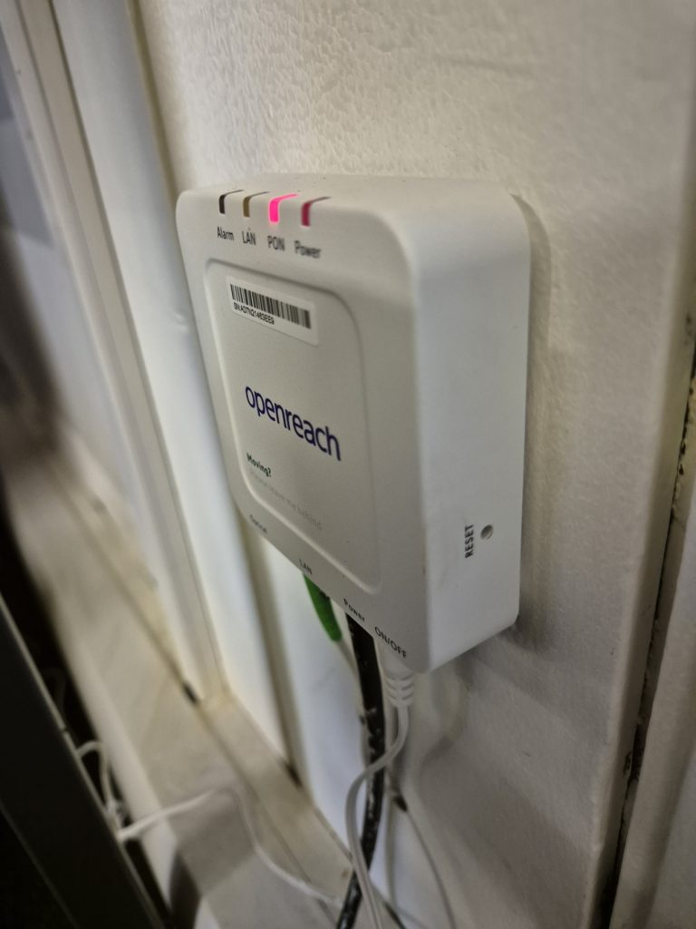 Close-up of a fibre ONT device with a red light indicator, showing a connectivity fault requiring repair or troubleshooting in Richmond Surrey