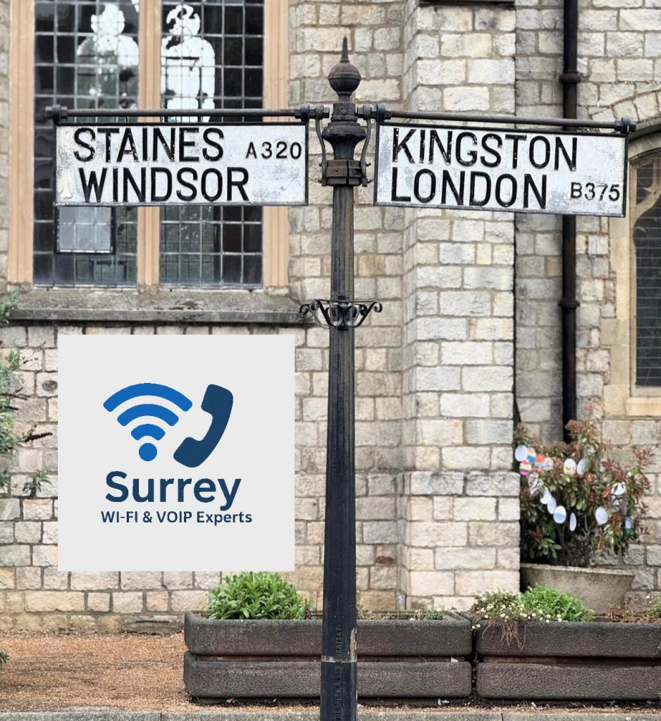 Surrey Wi-Fi & VoIP Experts logo displayed in front of a traditional signpost showing directions to Staines, Kingston, Windsor, and London.